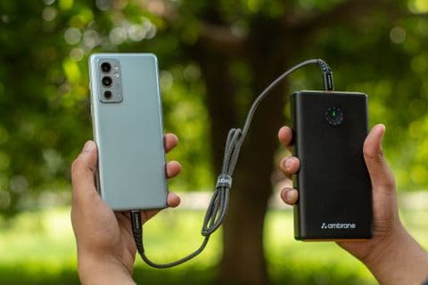 Hand holding a power bank while charging a smartphone